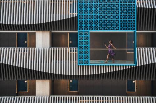 a woman walking in front of a building at Hotel Indigo Suzhou Jinji Lake by IHG in Suzhou
