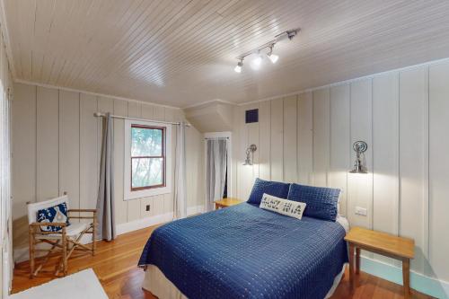 a bedroom with a blue bed and a window at Captain's Corner in Manzanita