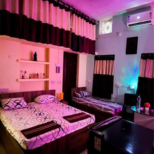 two beds in a room with purple lighting at JP Homestay - Nayapalli in Bhubaneshwar