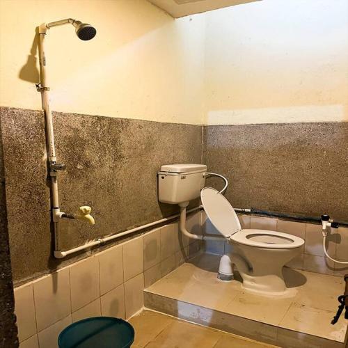 a bathroom with a toilet and a shower at JP Homestay - Nayapalli in Bhubaneshwar