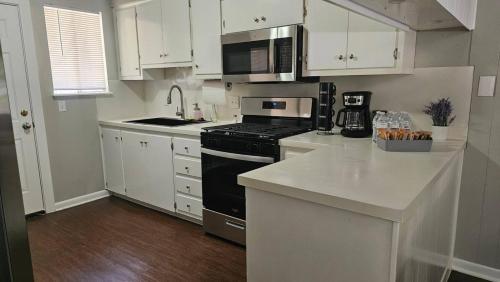 a kitchen with white cabinets and a black stove top oven at Homey 2br Home Near Downtown & Airport in Austin
