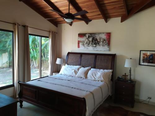 a bedroom with a large bed with a ceiling fan at Peaceful and Private Villa in Concepción