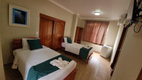 a hotel room with two beds with green and white at Diver's Den Casa en renta en Puerto Ayora , Islas Galapagos in Puerto Ayora