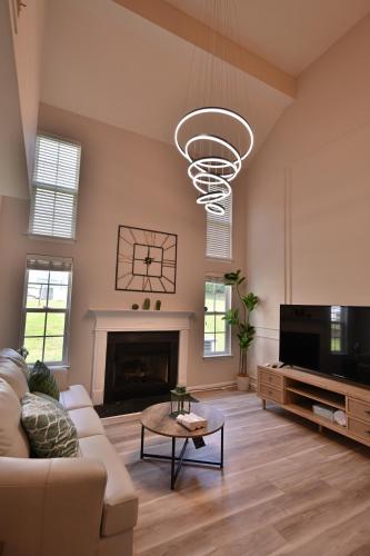 a living room with a couch and a tv and a fireplace at Amazing Renovated Townhouse in Greensboro
