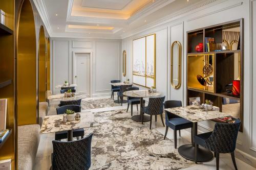 a restaurant with tables and chairs and a ceiling at InterContinental Athenee Palace Bucharest by IHG in Bucharest
