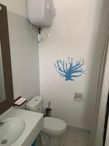 um banheiro com vaso sanitário branco e pia em Bluewave em Saint-François