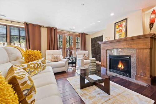 a living room with a white couch and a fireplace at Ascent 305 by East West Hospitality in Avon