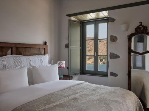 a bedroom with a large bed and a window at Patmos Eye Boutique Hotel & Villas in Skala