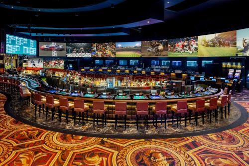a casino floor with a bar and chairs at Caesars Palace Hotel & Casino in Las Vegas