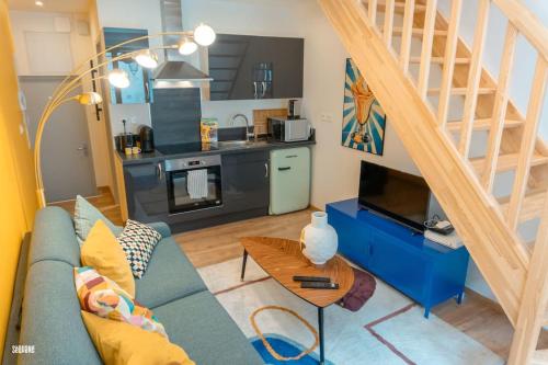 a living room with a blue couch and a kitchen at Hypercentre, calme, vintage - Le Rétro in Pontarlier