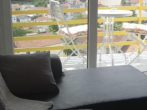 a black couch sitting next to a balcony with a table at Vista para a serra in Bragança