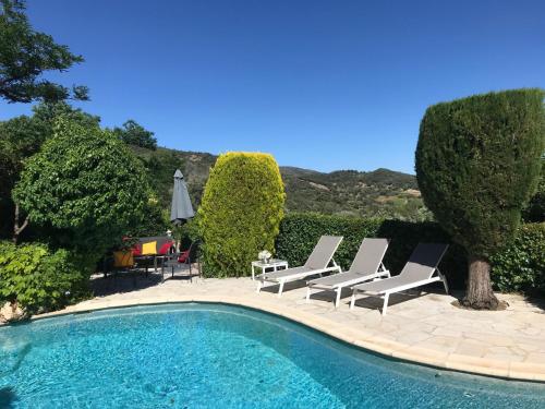 une piscine avec des chaises longues et un parasol dans l'établissement Villa Souleiadito dans le Golfe de Saint Tropez, au Plan-de-la-Tour