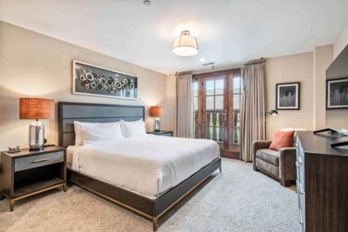 a bedroom with a bed and a desk and a chair at Ascent 312 by East West Hospitality in Avon