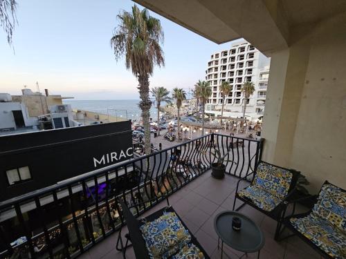 a balcony with chairs and a view of the ocean at Puzzle flat 2 in St. Paul's Bay