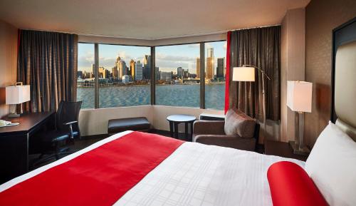 a hotel room with a large bed and a large window at Best Western Plus Waterfront Hotel in Windsor