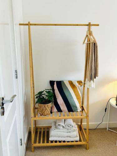 a shelf with towels and a plant on it at Cozy Glam Patchway Garden House Sleep 9 Mid-Long Term Welcome in Bristol