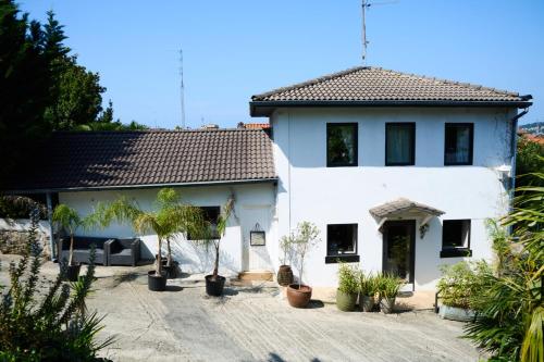 a white house with plants in front of it at Habitacion amigos peregrinos in Irún