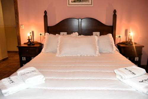 a large bed with white sheets and pillows at Casa Rural Nuri de Rei A y B in Todolella