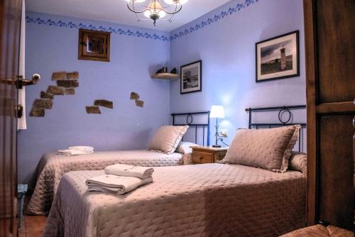 two beds in a room with blue walls at Casa Rural Nuri de Rei A y B in Todolella
