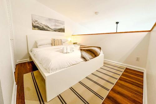 a white bed in a room with a staircase at Le Treehouse by Gestion ELITE in Mont-Tremblant