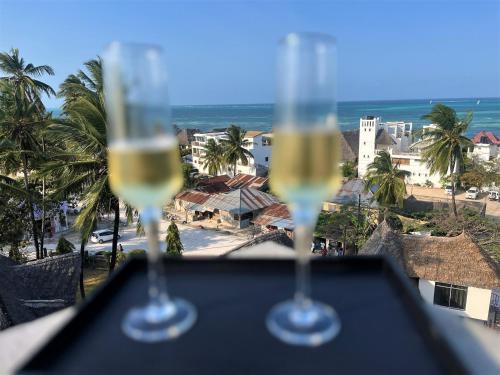 two glasses of white wine sitting on top of a table at Leparadis Zanzibar Boutique Hotel in Jambiani