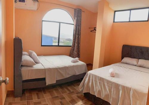 a room with two beds and a window at Departamento en San Cristóbal a 5 minutos del malecón, con 2 habitaciones, 4 camas, sala de estar, área de comedor, cocina equipada y excelente ubicación - Marysol - Galápagos Home in Puerto Baquerizo Moreno