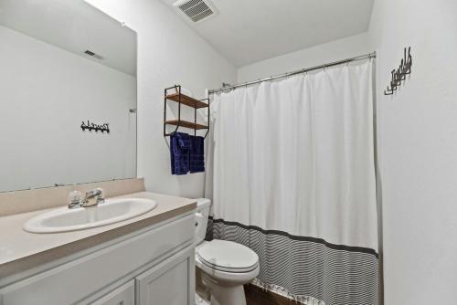 a white bathroom with a sink and a toilet at Perfect Home 4bdrm 2bath in Tomball