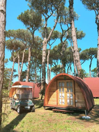 a tiny house and a car parked in front of trees at ISOLA VERDE Camping Village in Nettuno
