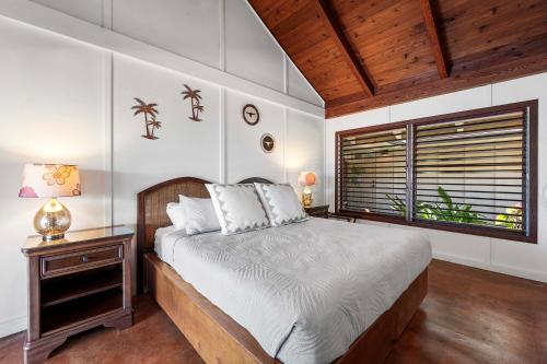 a bedroom with a large bed and a window at Hale Joli in Kailua-Kona