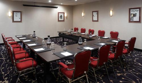 a conference room with a long table and red chairs at Best Western Plus Waterfront Hotel in Windsor