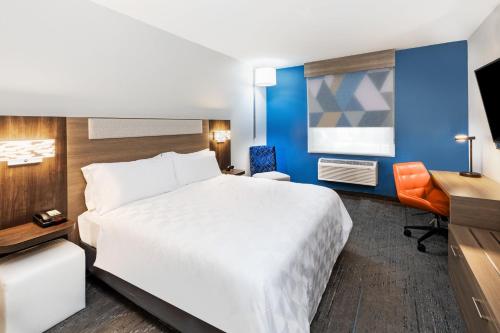 a hotel room with a white bed and a desk at Holiday Inn Express Harvey-Marrero by IHG in Harvey