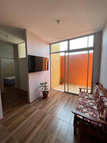 a living room with a couch and a sliding glass door at Casa Nataly in Tarapoto