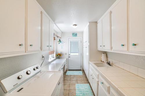 a white kitchen with white cabinets and a door at Pet-Friendly Riverside Retreat with Private Spa! in Riverside