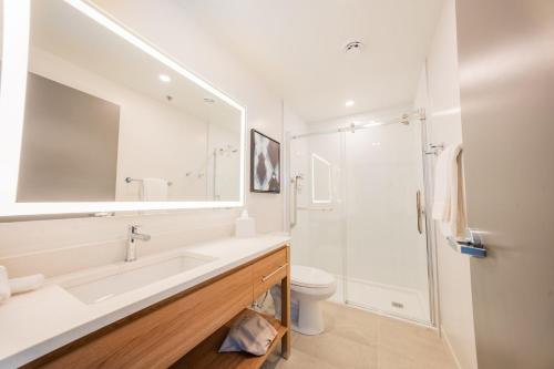 a white bathroom with a sink and a toilet at Candlewood Suites Trois-Rivières Ouest by IHG in Trois-Rivières