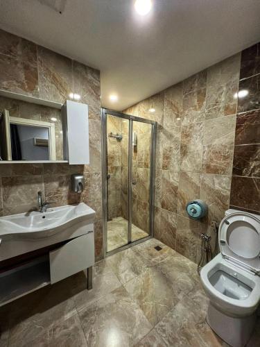 a bathroom with a toilet and a sink and a shower at Kuloğlu Otel ve Restoran in Uzungol