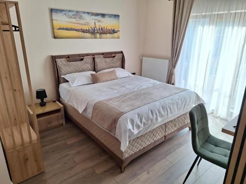 a bedroom with a large bed and a chair at Casa Don Felipe in Timişoara