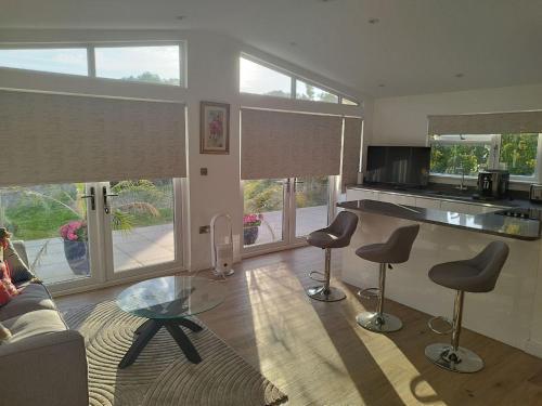 a living room with a couch and a table and chairs at The Hilltop Bungalow in Clophill