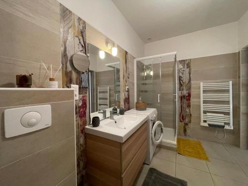 Un baño con lavabo, ducha e inodoro. en Joli appartement hypercentre T2, classé meublé de tourisme 3 avec parking gratuit, en Béziers