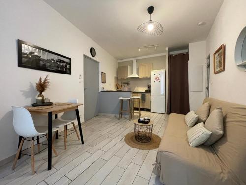 un salon et une cuisine avec un canapé et une table dans l'établissement Joli appartement hypercentre T2, classé meublé de tourisme 3 avec parking gratuit, à Béziers