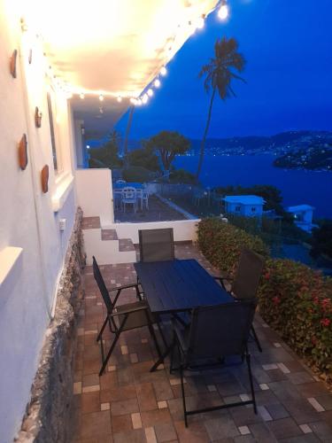 a patio with a table and chairs at night at Departamento con la mejor Vista de Acapulco in Acapulco