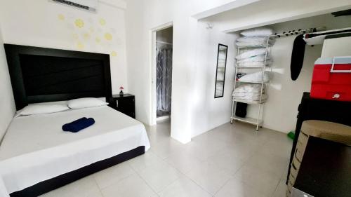a white bedroom with a bed and some towels at Departamento con la mejor Vista de Acapulco in Acapulco