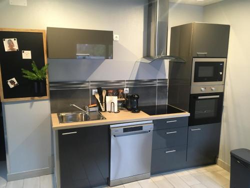 une petite cuisine avec un évier et une cuisinière dans l'établissement L appartement soleil de willerval, à Willerval
