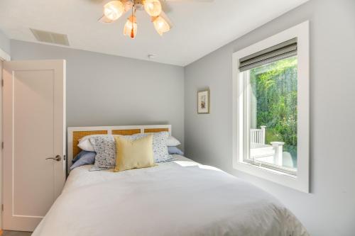 a white bedroom with a bed and a window at Coastal-Modern Home Less Than 3 Mi to Charlestown Beach! in South Kingstown