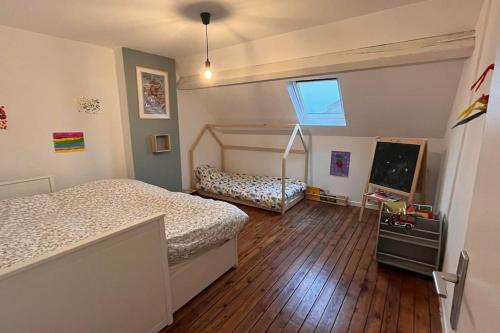 une chambre avec un lit et une télévision dans l'établissement Adorable maison avec jardin - Liévin centre, à Liévin