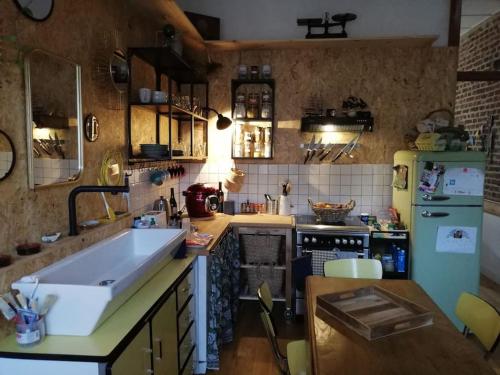 La cuisine est équipée d'un évier et d'un réfrigérateur vert. dans l'établissement Adorable maison avec jardin - Liévin centre, à Liévin