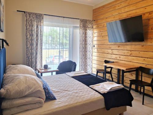 a bedroom with a bed and a flat screen tv at Żubr Nad Zalewem in Łuka