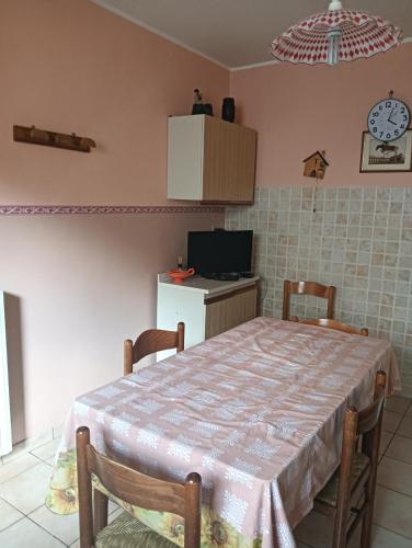 a kitchen with a table with chairs and a tv at La casa di Ninetta in Barisciano