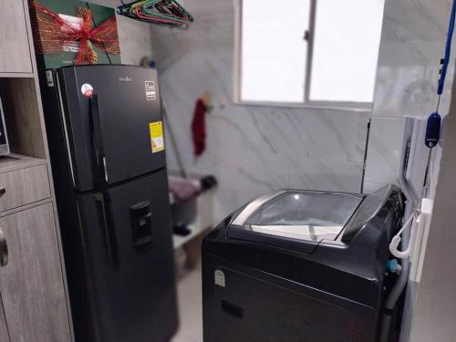 a kitchen with a black refrigerator and a toaster at Apartamento Cañaveral in Mirabel