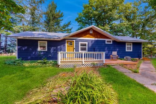 a blue tiny house with a porch at Lakeside Solitude in Deerwood