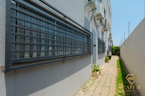 a building with windows on the side of a street at Zaffir Apartamento in Cuiabá